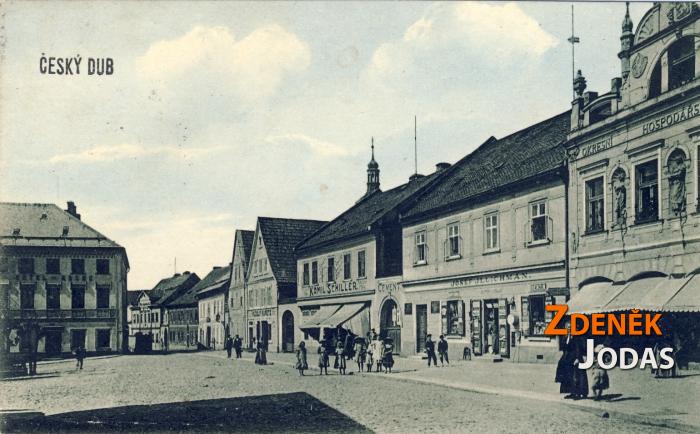 Pohled do jihozápadního rohu náměstí, kde ústí Kostelní ulice (kolem roku 1910). Domy západní fronty náměstí byly zbourány ve třicátých a padesátých letech. Dnes je zde nákupní středisko a budova pošty