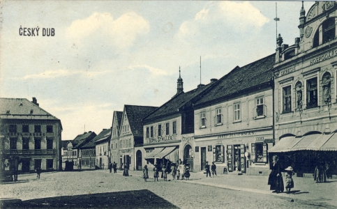Pohled do jihozápadního rohu náměstí, kde ústí Kostelní ulice (kolem roku 1910). Domy západní fronty náměstí byly zbourány ve třicátých a padesátých letech. Dnes je zde nákupní středisko a budova pošty